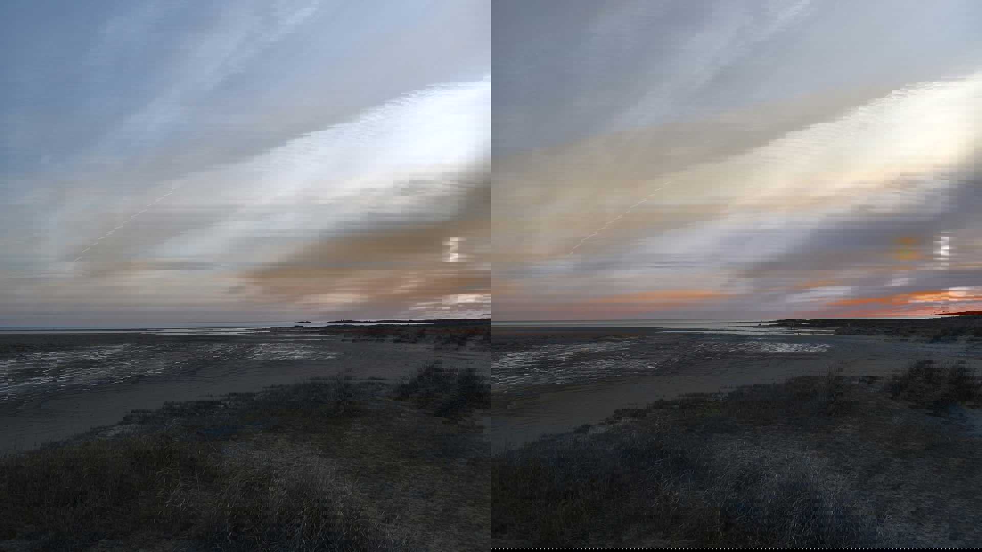 the sun is setting over the beach and water
